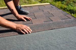 Roofing contractor lay asphalt shingles tiles on house rooftop as part of work Portillo Construction does as roofers Washington IL trusts